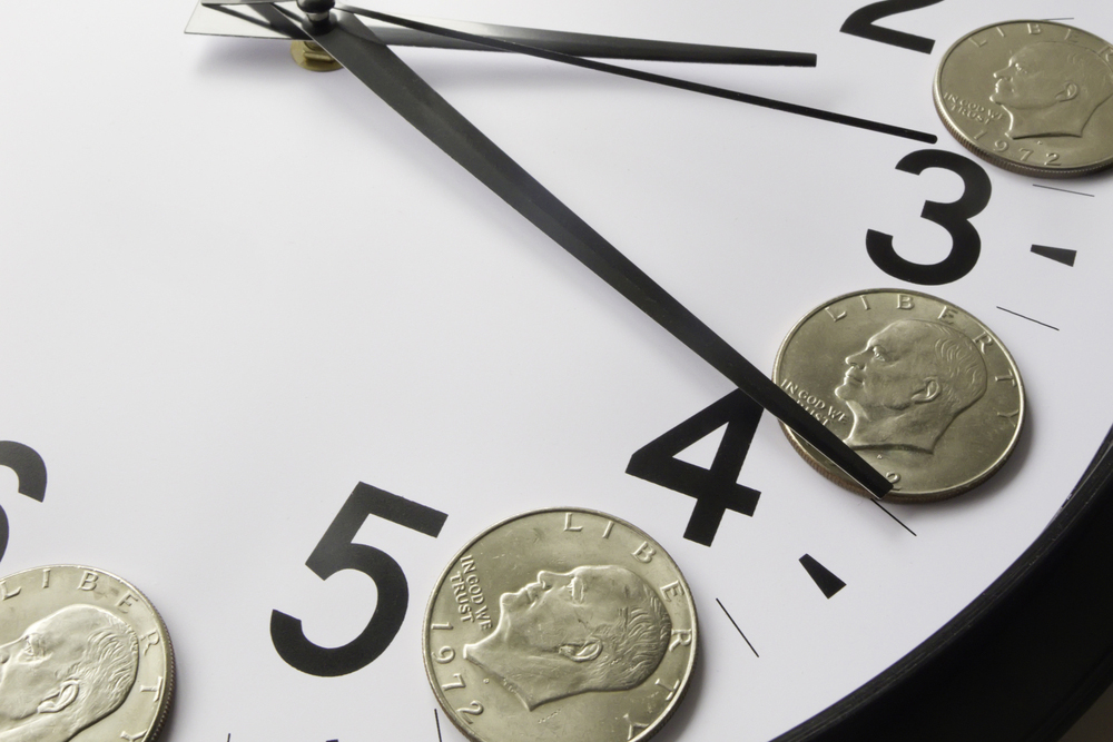 Concept of time is money Eisenhower dollar coins on face of analog clock-2